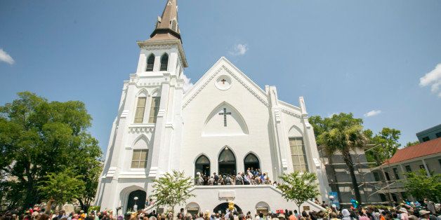 People stand outside as parishioners leave the Emanuel A.M.E. Church, Sunday, June 21, 2015, in Charleston, S.C., four days after a mass shooting at the church claimed the lives of its pastor and eight others. (AP Photo/Stephen B. Morton)