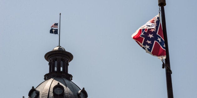 COLUMBIA, SC - JUNE 18: The South Carolina and American flags fly at half mast as the Confederate flag unfurls below at the Confederate Monument June 18, 2015 in Columbia, South Carolina. Legislators gathered Thursday morning to honor their co-worker Clementa Pinckney and the eight others killed yesterday at Emanuel AME Church in Charleston, South Carolina. (Photo by Sean Rayford/Getty Images)