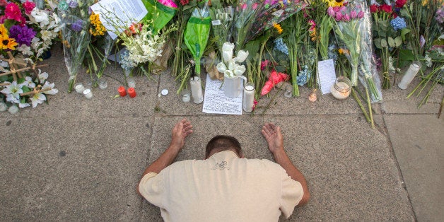 Raymond Smith of Charleston kneels in prayer at the front of the Emanuel AME Church before Sunday, June 21, 2015, before the first worship service since nine people were fatally shot at the church during a Bible study group, in Charleston, S.C. (AP Photo/Stephen B. Morton)