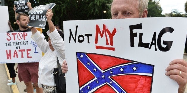 A man holds a sign up during a protest rally against the Confederate flag in Columbia, South Carolina on June 20, 2015. The r