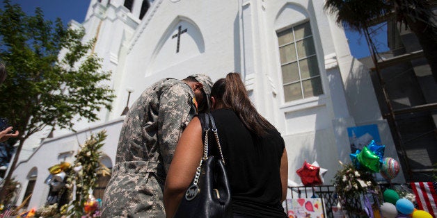 U.S. Army Spc. Ron Leary, left and Astride Leary, of Savannah, Ga., pray at a sidewalk memorial in memory of the shooting victims in front of Emanuel AME Church, Monday, June 22, 2015, in Charleston, S.C. (AP Photo/David Goldman)