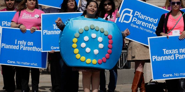 Alyssa Travino, center, of Edinburg, Texas, wears a birth control bill box costume during a Planned Parenthood rally on the steps of the Texas Capitol,Thursday, March 7, 2013, in Austin, Texas. (AP Photo/Eric Gay)