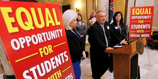 Ken Bartosek, of Clinton Miss., center, tells reporters how a more individualized education program at a private school helped his special needs son advance through his elementary, middle and high school years and is now a student at Mississippi State University studying forestry Tuesday, Feb. 25, 2014, at the Capitol in Jackson, Miss. Standing at left is Republican lawmakers Sen. Nancy Collins, of Tupelo, and Rep. Carolyn Crawford of Pass Christian. Parents who want Mississippi lawmakers to approve special education vouchers are adding their voices in support. (AP Photo/Rogelio V. Solis)