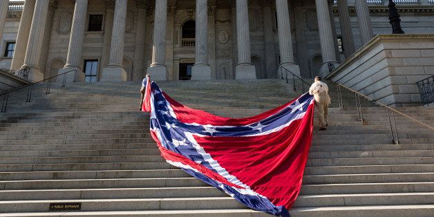 COLUMBIA, SC - MAY 02: Confederate re-enactors position a gigantic Confederate flag on the steps of the South Carolina State Capitol building on May 2, 2015 in Columbia, SC. Confederate Memorial Day is a official state holiday in South Carolina and honors those that served during the Civil War. (Photo by Richard Ellis/Getty Images)