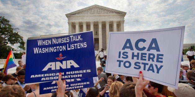 Supporters of the Affordable Care Act hold up signs as the opinion for health care is reported outside of the Supreme Court in Washington, Thursday June 25, 2015. The Supreme Court on Thursday upheld the nationwide tax subsidies under President Barack Obama's health care overhaul, in a ruling that preserves health insurance for millions of Americans. The justices said in a 6-3 ruling that the subsidies that 8.7 million people currently receive to make insurance affordable do not depend on where they live, under the 2010 health care law. (AP Photo/Jacquelyn Martin)