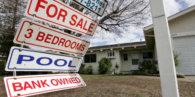 FILE - In this file photograph taken Feb. 23, 2009, a foreclosure sign blows in the wind in front of a home under foreclosure
