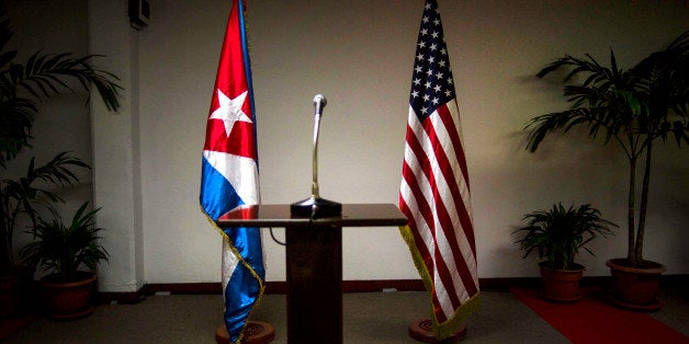 FILE - In this Jan. 22, 2015 file photo, a Cuban and U.S. flag stand before the start of a press conference on the sidelines of talks between the two nations in Havana, Cuba. The U.S. hopes to open an embassy in Havana before presidents Barack Obama and Raul Castro meet at a regional summit in April, which will be the scene of the presidentsâ first face-to-face meeting since they announced on Dec. 17 that they will re-establish diplomatic relations after a half-century of hostility. (AP Photo/Ramon Espinosa, File)