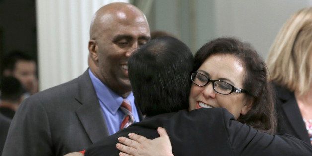 State Sen. Richard Pan, D-Sacramento, left, is hugged by Assemblywoman Lorena Gonzalaz, D-San Diego after his measure requiring nearly all California school children to be vaccinated was approved by the Assembly at the Capitol in Sacramento, Calif., Thursday, June 25, 2015. Gonzalez carried the bill, SB277 co-authored by Pan and State Sen. Ben Allen D-Santa Monica in the Assembly. The measure now goes to the governor. (AP Photo/Rich Pedroncelli)