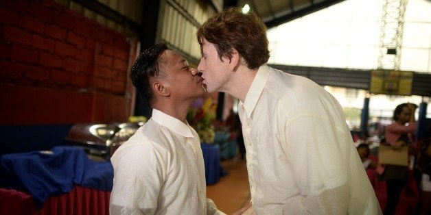 US Michael Ellis (R) and Filipino Jesus Bascal (L) kiss during a 'Rite of Holy Union' ceremony for the Lesbians Gays Bisexual