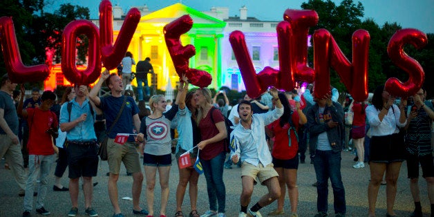 Same-sex marriage supporters hold up balloons that spell the words "love wins" as they stand in front of the White House, whi