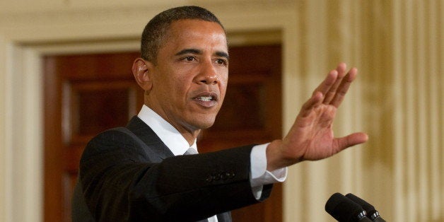 US President Barack Obama motions for a heckler to stop shouting as he speaks about the administration's national HIV / AIDS