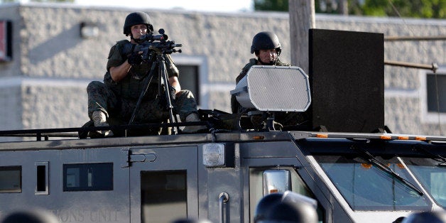 FILE - In this Aug. 9, 2014 file photo, a police tactical team moves in to disperse a group of protesters in Ferguson, Mo. th