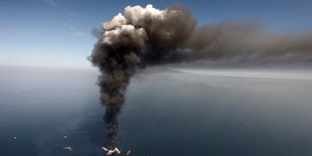 FILE - In this April 21, 2010 file photo, oil can be seen in the Gulf of Mexico, more than 50 miles southeast of Venice on Louisiana's tip, as a large plume of smoke rises from fires on BP's Deepwater Horizon offshore oil rig. A week shy of the fifth anniversary of the Deepwater Horizon oil spill, the Obama administration proposed new regulations Monday aimed at strengthening oversight of offshore oil drilling equipment and ensuring that out-of-control wells can be sealed in an emergency. (AP Photo/Gerald Herbert, File)
