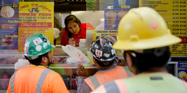 Construction workers order lunch from a food truck vender Tuesday, Sept. 16, 2014, in Philadelphia. (AP Photo/Matt Rourke)