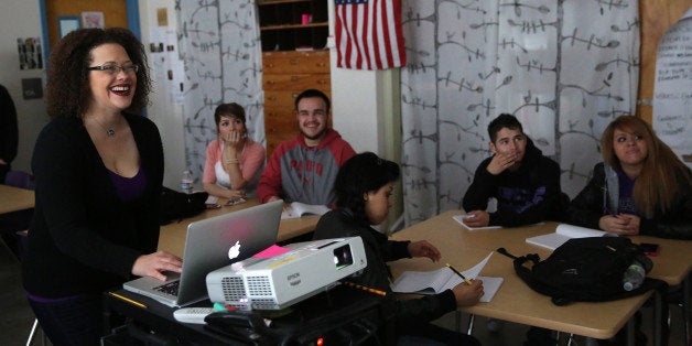 In this Feb. 10, 2014 photo, slam poet and Youth on Record teacher Suzy Q. Smith smiles as she projects a video for students during a poetry class at Lincoln Respect Academy, a program for at risk students operated inside Lincoln High, a public high school in Denver. Founded by hip hop group the Flobots, Youth on Record recruits artists, trains them to teach, and puts instruments and professional recording equipment in the hands of young people. It reaches 700 students a year, and currently is working in four Denver high schools and two residential treatment centers. (AP Photo/Brennan Linsley)