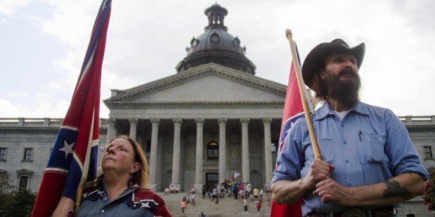 Pro-confederate flag demonstrators Jim Horky (R) and his wife Alice (L) stand outside the South Carolina State House in Columbia, South Carolina, June 27, 2015. There has been a growing clamor for the flag -- branded 'a reminder of systemic oppression and racist subjugation' by President Barack Obama on Friday -- to be removed from the grounds of the state house in Columbia. Once flown by the rebel army of the slave-owning South, the confederate flag is seen by some as a symbol of regional heritage, but by many more as an ugly reminder of racism's cruel legacy. AFP PHOTO/JIM WATSON (Photo credit should read JIM WATSON/AFP/Getty Images)