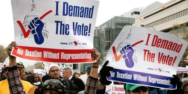 WASHINGTON - APRIL 16: Demonstrators hold posters during a march to ask for a voting representation for the nation's capital in the U.S. House of Representatives April 16, 2007 in Washington, DC. Thousands of residents of Washington, DC, marched to Capitol Hill to demand a voting right for the District. (Photo by Alex Wong/Getty Images)