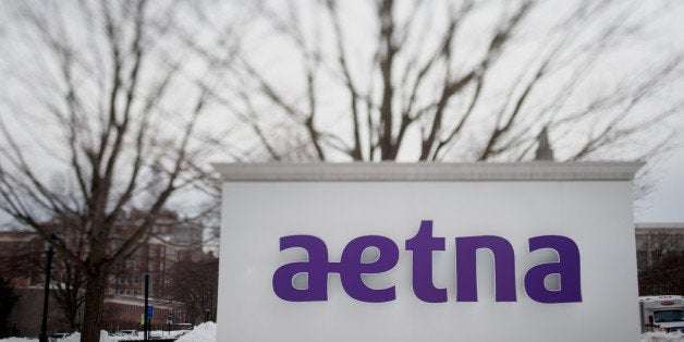 Snow covers the ground around Aetna Inc. signage displayed outside of the company's corporate headquarters in this photo take