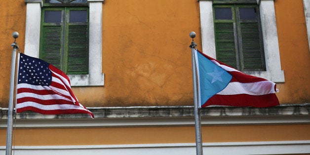 SAN JUAN, PUERTO RICO - JUNE 30: An American flag and Puerto Rican flag fly next to each other in Old San Juan a day after t