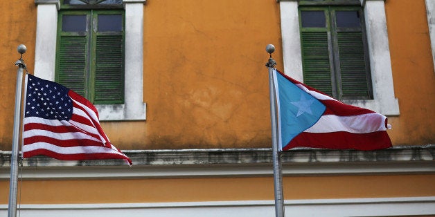 SAN JUAN, PUERTO RICO - JUNE 30: An American flag and Puerto Rican flag fly next to each other in Old San Juan a day after the Puerto Rican Governor Alejandro Garcia Padilla gave a televised speech regarding the governments $72 billion debt on June 30, 2015 in San Juan, Puerto Rico. The Governor said in his speech that the people will have to sacrifice and share in the responsibilities for pulling the island out of debt. (Photo by Joe Raedle/Getty Images)