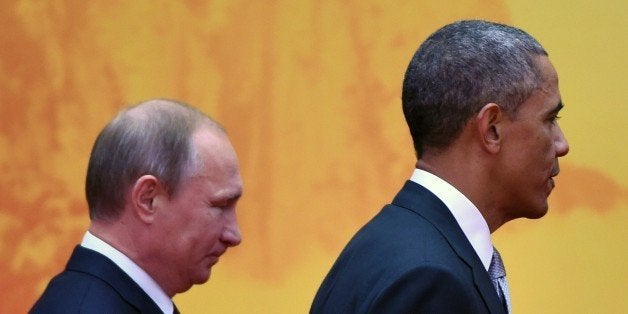 US President Barack Obama walks to a group photo session with Russian President Vladimir Putin (L) at the Asia-Pacific Economic Cooperation (APEC) summit at Yanqi Lake, north of Beijing on November 11, 2014. Top leaders and ministers of the 21-member APEC grouping are meeting in Beijing from November 7 to 11. AFP PHOTO/Greg BAKER (Photo credit should read GREG BAKER/AFP/Getty Images)