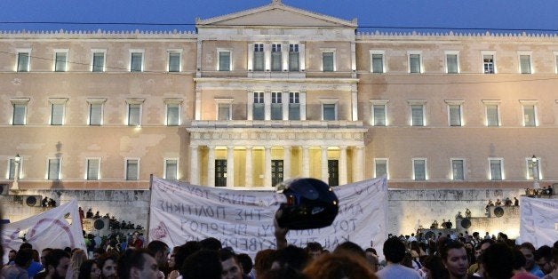 Greek riot police stand on the steps leading up to the parliament building in Athens, as leftist protesters hold an anti-EU demonstration in Athens calling for no any agreement with the creditors which would lead to further austerity measures to the nation on July 12, 2015. Eurozone leaders set Greece brutal take-it-or-leave-it conditions for a desperately needed bailout deal at a summit as a catastrophic exit from the single currency loomed ever larger. AFP PHOTO/ LOUISA GOULIAMAKI (Photo credit should read LOUISA GOULIAMAKI/AFP/Getty Images)