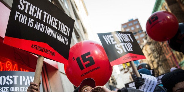 NEW YORK, NY - DECEMBER 04: Protesters march through the streets demanding a raise on the minimum wage to $15 per hour on December 4, 2014 in New York, United States. The movement, driven largely by fast food workers, has risen in prominence in the past year; today's protests were also joined by demonstrators angry at the Grand jury verdict to not indict the police officer who killed Eric Garner in July, 2014. (Photo by Andrew Burton/Getty Images)