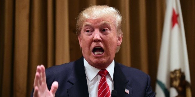 Donald Trump gestures at a press briefing where he introduced people whose families were victims of illegal immigrants on Jul