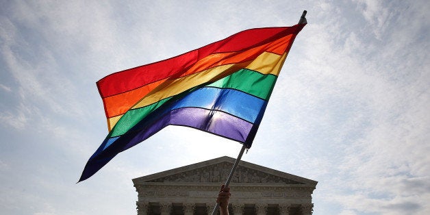 WASHINGTON, DC - JUNE 25: A gay marriage waves a flag in front of the Supreme Court Building June 25, 2015 in Washington, DC. The high court is expected rule in the next few days on whether states can prohibit same sex marriage, as 13 states currently do. (Photo by Mark Wilson/Getty Images)