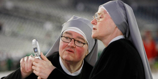 Little Sisters of the Poor Sister Kathleen Marie, right, shows Sister Ann Marguerite how to use their communal cell phone in