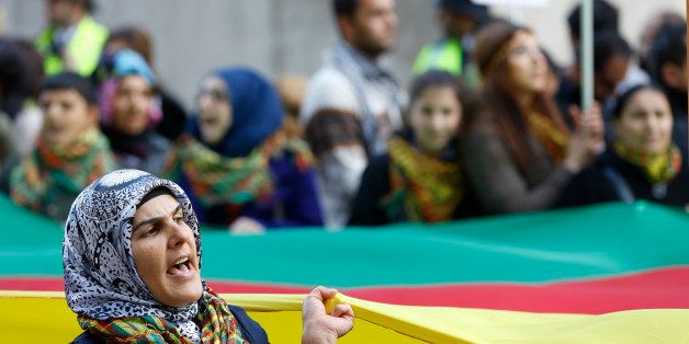 A woman shouts during a protest near Parliament Square in London, Saturday, Oct. 11, 2014. Demonstrators were calling for support for the Kurdish resistance against the Islamic State group in Kobani and Rojava. (AP Photo/Kirsty Wigglesworth)