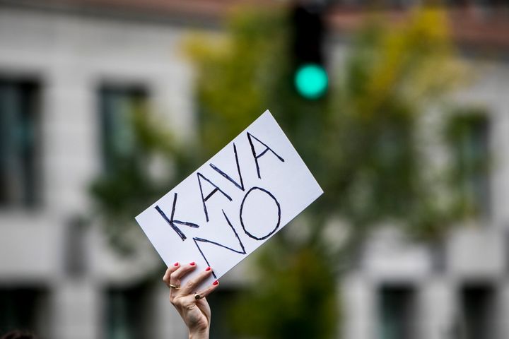 A protestor holds up an anti-Kavanaugh sign 