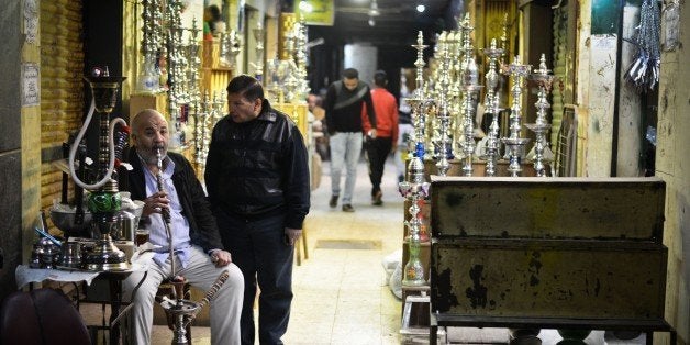An Egyptian man smokes a water pipe not far from al-Moez street in Cairos Khan al-Khalili district on February 20, 2015. Al-M
