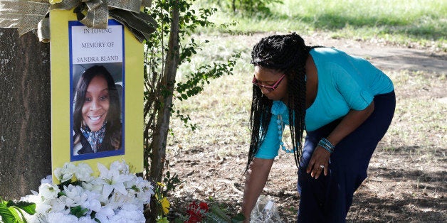 Jeanette Williams places a bouquet of roses at a memorial for Sandra Bland near Prairie View A&M University, Tuesday, Jul