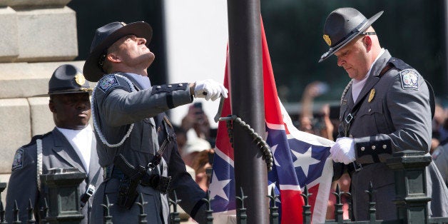 An honor guard from the South Carolina Highway patrol removes the Confederate battle flag from the Capitol grounds Friday, July 10, 2015, in Columbia, S.C. (AP Photo/John Bazemore)