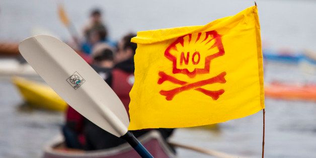 SEATTLE, WA - MAY 16: A ShellNo flotilla participant paddles in a kayak with an anti-Shell flag during demonstrations against Royal Dutch Shell on May 16, 2015 in Seattle, Washington. On Saturday demonstrators began three days of protests both on land and on Puget Sound over the presence of the first of two Royal Dutch Shell oil rigs in the Port of Seattle. (Photo by David Ryder/Getty Images)
