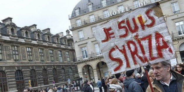 A protester holds a placard reading 'I am Syriza' during a demonstration in support of the Greek people on February 15, 2015