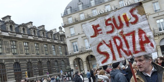 A protester holds a placard reading 'I am Syriza' during a demonstration in support of the Greek people on February 15, 2015 in Paris. At least 2,000 people marched through the streets of Paris on February 15 heeding the call from unions and far-left organisations to voice their support for Greece and its new leftist anti-austerity government. AFP PHOTO / LOIC VENANCE (Photo credit should read LOIC VENANCE/AFP/Getty Images)