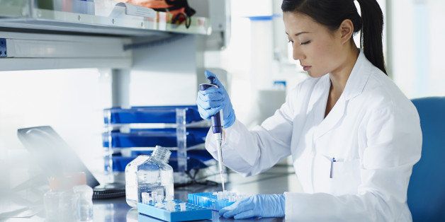Scientist pipetting samples into eppendorf tubes in research laboratory