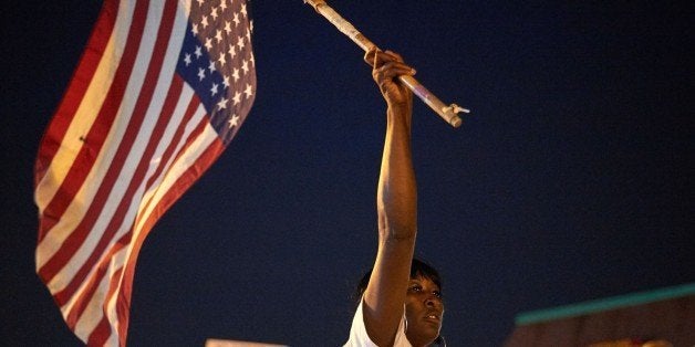 Demonstrators protest during a march on August 8, 2015 at the Ferguson Police Department in Ferguson, Missouri. Several hundred people marched Saturday in Ferguson to mark the first anniversary of the police shooting of unarmed black teen Michael Brown, which shone a spotlight on race relations in America. The crowd worked its way along one of the avenues hit by fierce rioting last November when a court decided not to indict the white officer who shot 18-year-old Brown. AFP PHOTO/MICHAEL B. THOMAS (Photo credit should read Michael B. Thomas/AFP/Getty Images)