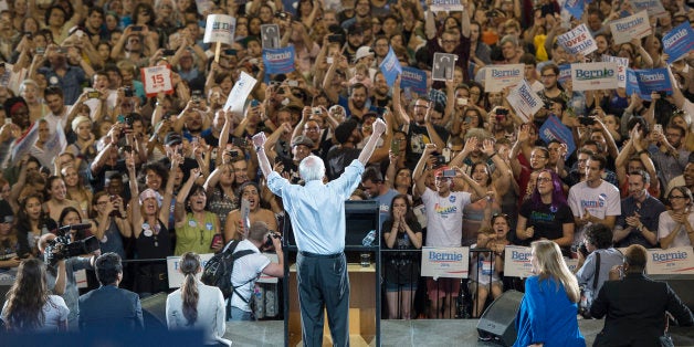 Democratic presidential candidate Sen. Bernie Sanders, I-Vt., lifts his arms in celebration as he speaks at a rally, Sunday,