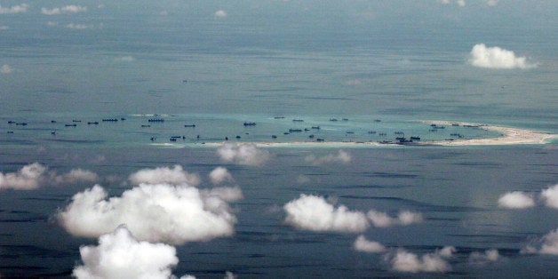 This areal photo taken through a glass window of a military plane shows China's alleged on-going reclamation of Mischief Reef in the Spratly Islands in the South China Sea Monday, May 11, 2015. Gen. Gregorio Pio Catapang, the Philippines' military chief, has flown to Pag-asa Island, a Filipino-occupied island in the South China Sea amid territorial disputes in the area with China, vowing to defend the islet and help the mayor develop tourism and marine resources there. (Ritchie B. Tongo/Pool Photo via AP)