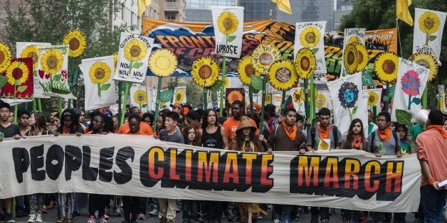 Demonstrators hold signs on a street next to Central Park during the People's Climate March in New York, U.S., on Sept. 21, 2014. The United Nations 2014 Climate Summit is scheduled for Sept. 23. Photographer: Timothy Fadek/Bloomberg via Getty Images