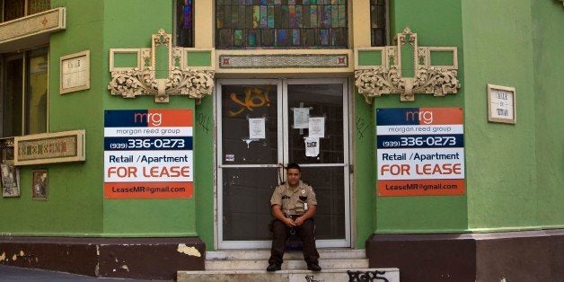 A private security guard sits in front of a closed down business in the colonial district of Old San Juan, Puerto Rico, Sunda