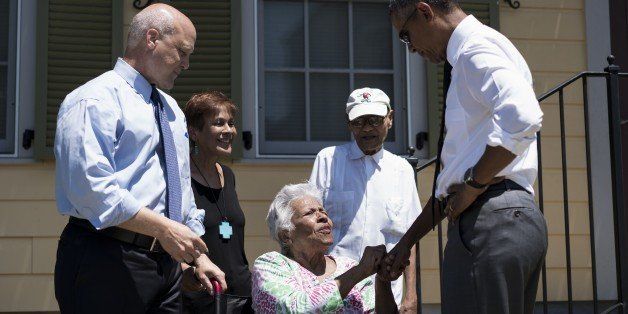 New Orleans Mayor Mitch Landrieu (L) and US President Barack Obama (R) meet residents during a tour of the Treme neighborhood August 27, 2015 in New Orleans, Louisiana. President Obama visited New Orleans Thursday to praise its people's 'extraordinary resilience,' 10 years after Hurricane Katrina ravaged the 'Big Easy' and shattered Americans' confidence in government.AFP PHOTO/BRENDAN SMIALOWSKI (Photo credit should read BRENDAN SMIALOWSKI/AFP/Getty Images)