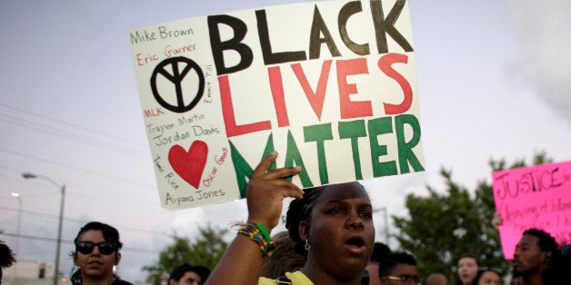 Desiree Griffiths, 31, of Miami, holds up a sign saying "Black Lives Matter", with the names of Michael Brown and Eric Garner