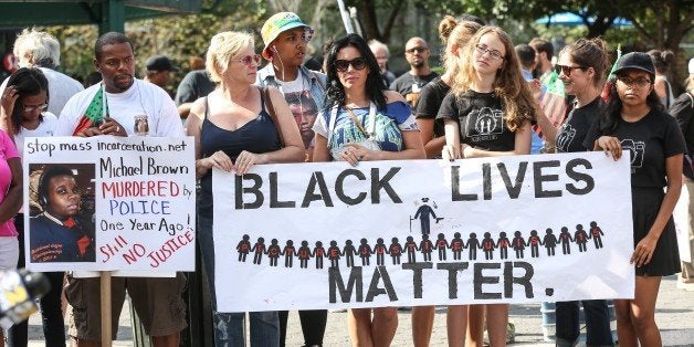 NEW YORK, NY - AUGUST 09: People hold banners reading 'Black Lives Matter' during a rally to mark the one year anniversary of the death of Michael Brown at Union Square in New York, NY on August 09, 2015. Brown was killed by police officer Darren Wilson in Ferguson, Missouri, and his death set off nationwide protest against police brutality. (Photo by Cem Ozdel/Anadolu Agency/Getty Images)