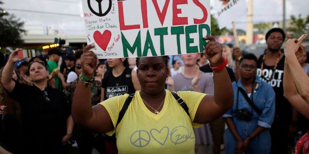 Desiree Griffiths, 31, of Miami, holds up a sign saying "Black Lives Matter", with the names of Michael Brown and Eric Garner, two black men recently killed by police, during a protest Friday, Dec. 5, 2014, in Miami. People are protesting nationwide against recent decisions not to prosecute white police officers involved in the killing of black men. (AP Photo/Lynne Sladky)