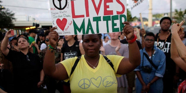 Desiree Griffiths, 31, of Miami, holds up a sign saying "Black Lives Matter", with the names of Michael Brown and Eric Garner