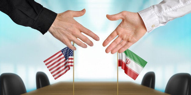 Two diplomats from the United States and Iran extending their hands for a handshake on an agreement between the countries.